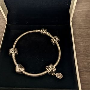 Authentic Pandora silver bracelet with 4 charms. 7 inch. split heart sold